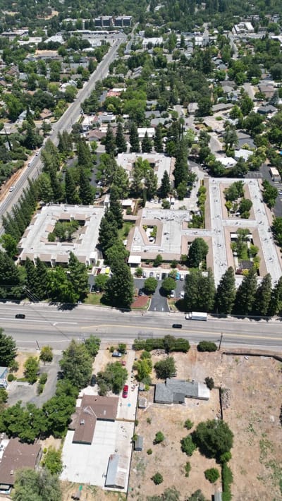 Aerial view of a senior living campus surrounded by trees