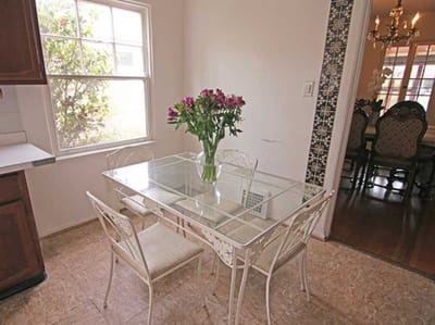 Dining table with flowers in a well-lit kitchen