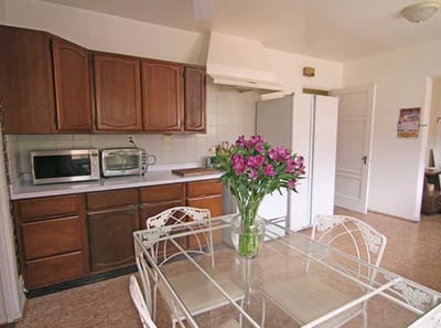 Bright kitchen area with a dining table and flowers