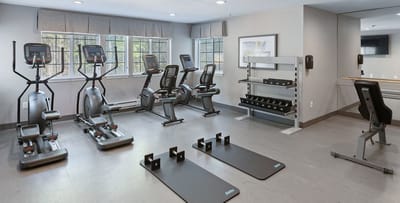 Modern fitness room with exercise equipment and mats