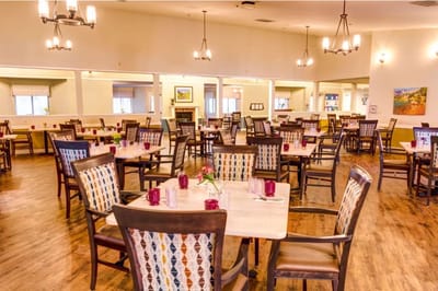 Brightly lit dining room with tables set for meals