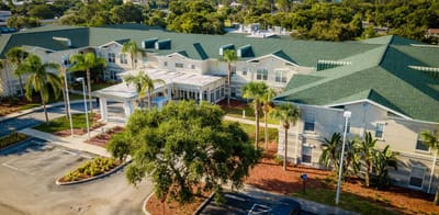 Aerial view of a senior living facility with gardens and parking