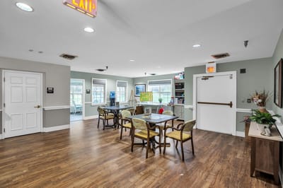 Common area with tables and seating in a senior living facility