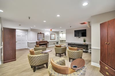Common area with seating and piano in a senior living facility