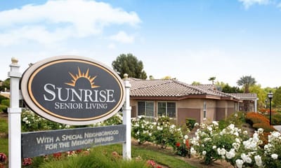 Exterior view of Sunrise Senior Living facility with gardens