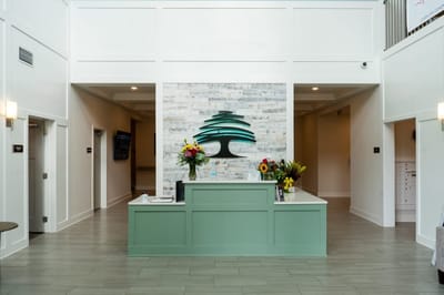 Bright lobby area with reception desk and floral arrangements