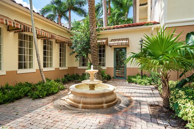 An outdoor courtyard with a fountain surrounded by greenery