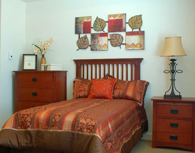 Cozy resident room with decorated bed and furniture