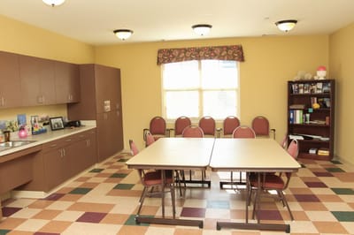 Interior view of a common activity room with tables and chairs