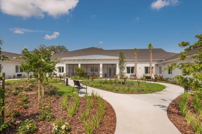 Exterior view of a senior living facility with gardens