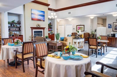 Bright dining area with tables and chairs, floral decorations