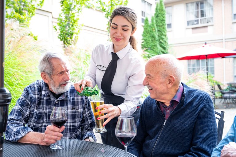Staff serving drinks to residents in an outdoor space