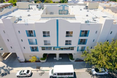Exterior view of Harbor Terrace building with shuttle bus