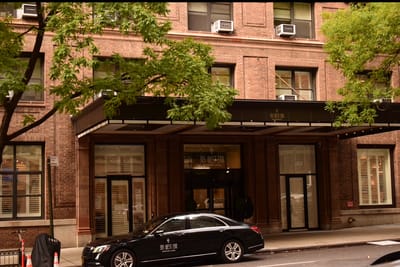 Exterior view of a senior living facility with a car