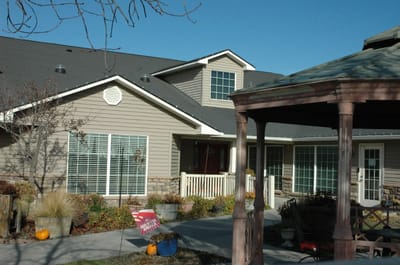 Exterior view of a senior living facility with a gazebo and landscaping