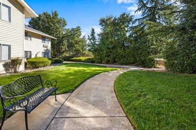 Pathway with a bench in the garden at Hilltop Estates