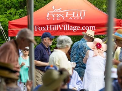Residents enjoying an event under a Fox Hill Village tent