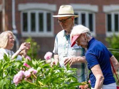 Residents enjoying a garden with blooming flowers