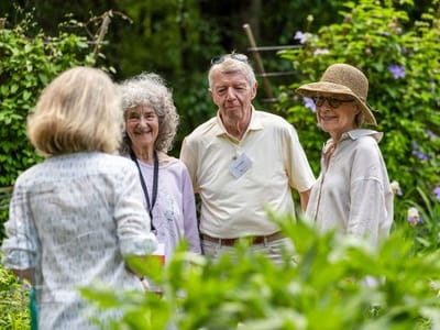 Residents enjoying a garden gathering in a lush setting.