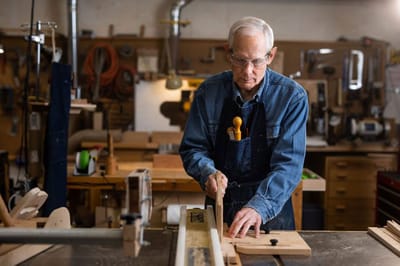 A resident crafting woodwork in a workshop