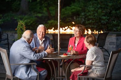 Residents enjoying drinks by an outdoor fire pit