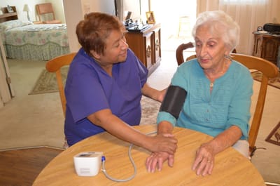 A caregiver checking a senior's blood pressure