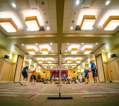 Residents playing pickleball in an activity room