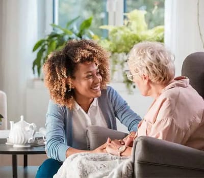 A caregiver engaging with a senior resident in a cozy setting