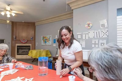 Staff member engaging residents in a craft activity