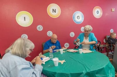 Residents engaged in a bingo activity inside.