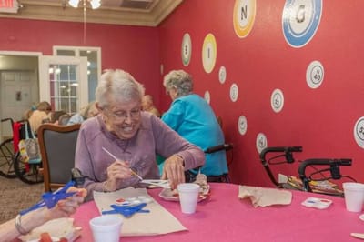 Residents engaging in arts and crafts in a colorful activity room