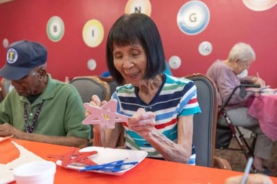 Residents participating in a craft activity at a long table