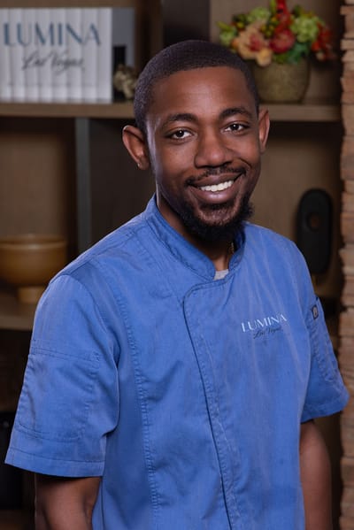 Staff member in a kitchen setting with a welcoming smile