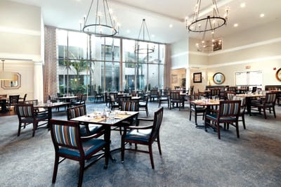 Bright dining room with tables and chairs set for meals