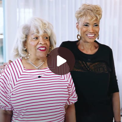 Two women smiling and posing together indoors