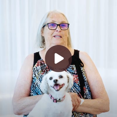 A resident with a small dog in a bright indoor setting