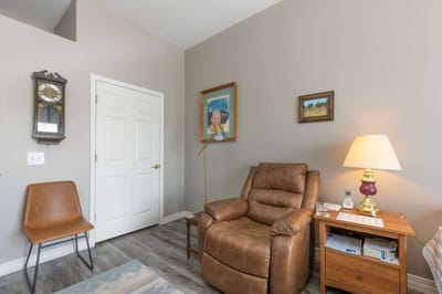 Cozy interior of a resident's room with a recliner and lamp