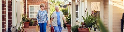 Two women walking in a garden area