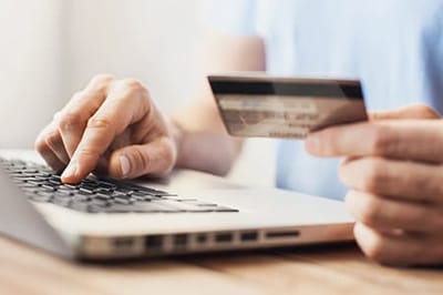 Person using a credit card on a laptop