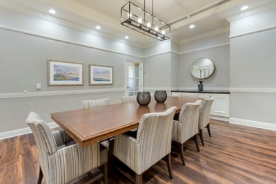 A well-lit dining room with a large wooden table