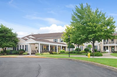 Exterior view of a senior living facility with gardens