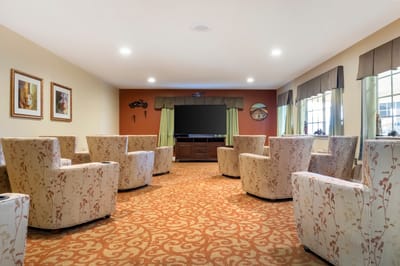 Bright common area with armchairs and a television