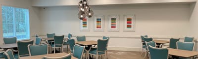 Bright common area with turquoise chairs and art