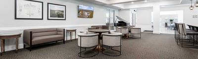 Common area with seating and piano in a senior living facility