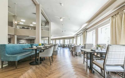 Bright dining room with seating and floral centerpieces