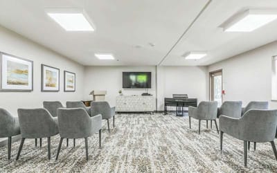 Bright activity room with chairs and piano