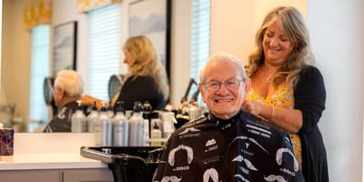 Resident getting a haircut in the salon with a stylist