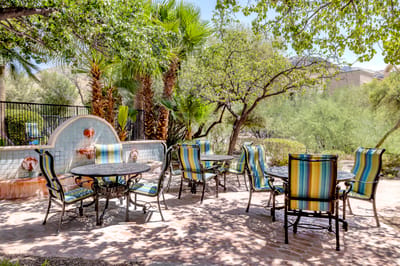 Outdoor seating area with colorful chairs and greenery.