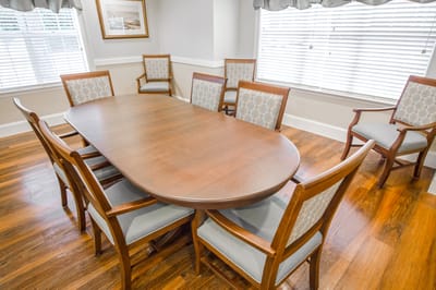 Bright common area with a large wooden table and chairs