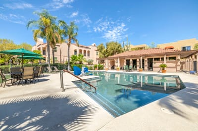 Outdoor pool area with lounge chairs and palm trees